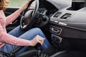 Woman driving car. Female hand change speed on the manual gearbox